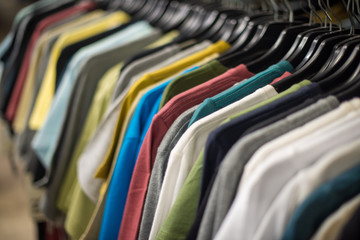 Assortment of t shirts hanging on rack