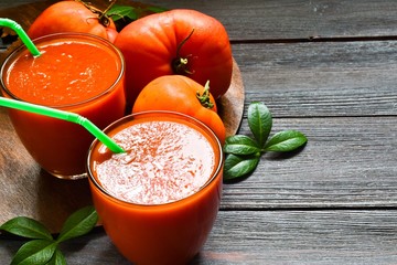 Glasses of fresh tomato juice on a wooden background. close-up.