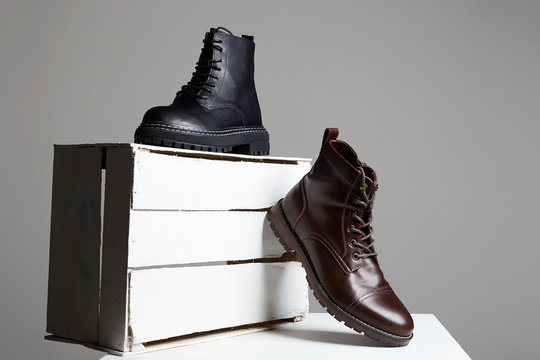 Trendy boots with white wooden box. fashion shoes still life
