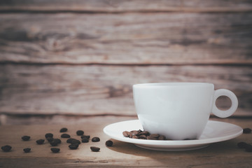 A white hot coffee cup with a saucer is placed on a wooden plate and on a wooden background.front view.