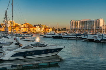Vilamoura Marina, Portugal. Sunset from this exclusive place surrounded by boats and luxury hotels. - obrazy, fototapety, plakaty