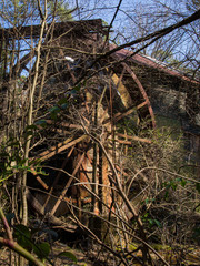 Abandoned grist mill and water wheel being over grown by the surrounding forest