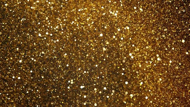 Super slow motion of glittering coloured particles on black background. Shallow depth of focus. Filmed on high speed cinema camera, 1000 fps.