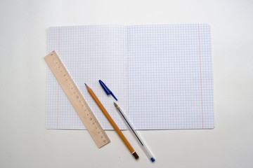 Opened school notebook with pen, pencil and line on it