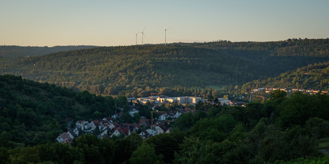 German village with forest and wind power turbines