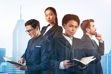 Group of four business colleagues in suits working on project together to gain new career...
