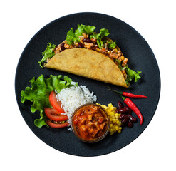 Top view Hot taco with ingridients and salsa on the black plate isolated