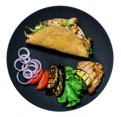 Top view taco with with fried chicken meat and vegetables, and ingredients on the black plate isolated