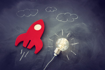 education or innovation concept. Wooden rocket over blackboard background. top view