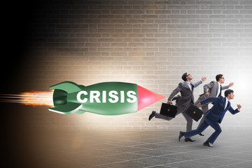 Obraz premium Concept of crisis with businessman chased by rocket