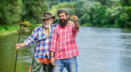 come back home. hobby and sport activity. Trout bait. two happy fisherman with fishing rods. father...