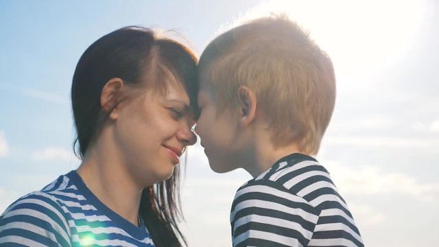 A beautiful happy family. Mother and son touch their noses. Family in the sunshine enjoy the positive emotions of reunion and a good life. Happy childhood and motherhood.