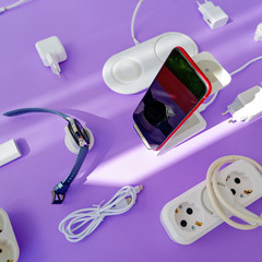 The concept of wireless charging of mobile gadgets. The smartphone and smartwatch are on the...