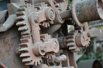 Rusted spur gears on vintage logging equipment.