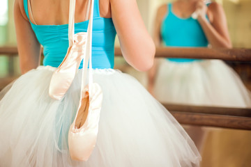 Woman at dance ballet class holding pointe shoes. Lifestyle and sport concept