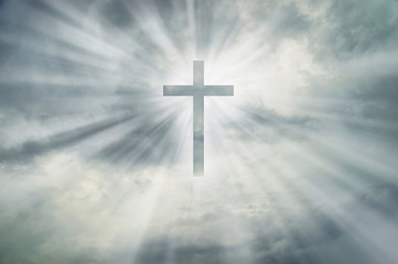 Christian cross appears bright on dramatic dark sky