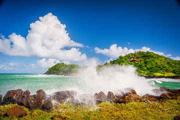 Breathtaking photo of a beach in the Caribbean where water is splashing over rocks