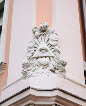 The symbol of the all-seeing eye with rays and seraphim. A sculptural composition at the corner of a house in Lviv, Ukraine.