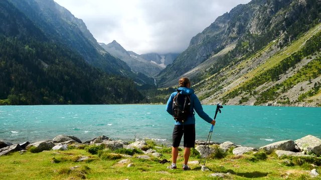 hiker man looking at beautiful mountain blue lake