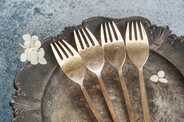 Old bronze forks on vintage dish