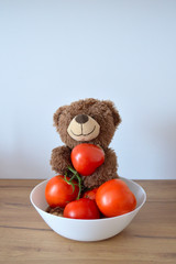 Sweet teddy bear and tomatoes in a bowl © Designak