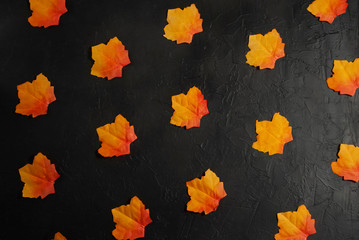 Autumn fallen leaves pattern on the black stone background top view