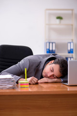 Young male employee sleeping in the office