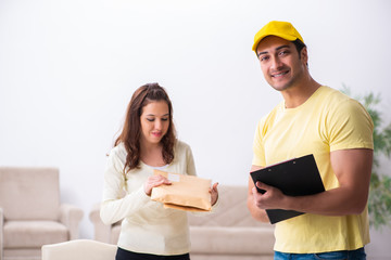 Young male courier delivering parcel to the office