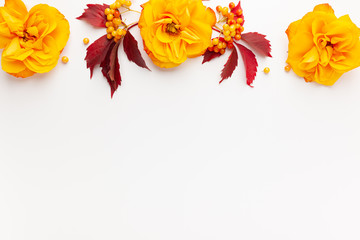 Autumn composition with flowers, leaves and berries on white background. Flat lay, copy space.