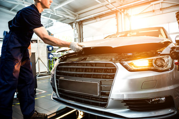 Car mechanic repair engine at service station. Car repair