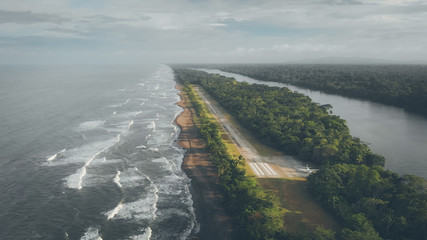 Kleiner Flugplatz an der Küste in Costa Rica, direkt am Regenwald mit Cessna Grand Caravan neben...