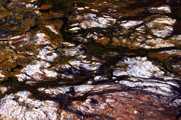 The texture of geyserite near thermal springs forms a multicolored beautiful bright abstract natural background,simulating a view from above of a rocky area