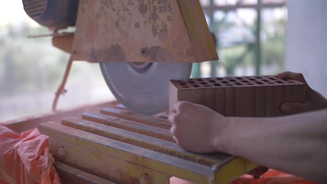 sawing red brick with a circular saw