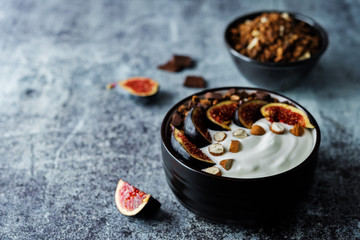 Greek yogurt chocolate almond nuts oatmeal granola with figs in a bowl