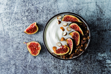 Greek yogurt chocolate almond nuts oatmeal granola with figs in a bowl