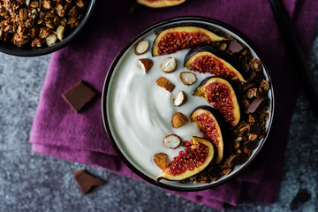 Greek yogurt chocolate almond nuts oatmeal granola with figs in a bowl