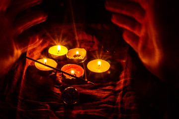 Smoke from candles and scented candles. The beginning of divination, witchcraft, magic. A woman's hands conjure.