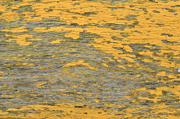 Texture of shabby, yellow paint on an old wooden surface