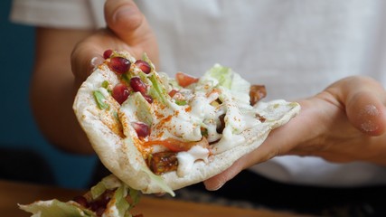 Close up of healthy vegan pitas stuffed with vegetables and decorated with pomegranate seeds. Healthy vegan lifestyle. 