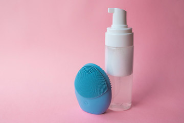 Silicone brush for washing face and cosmetic foam. Beauty and skincare concept.  Blue facial...