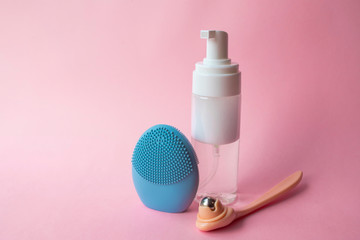 Silicone brush for washing face and cosmetic foam. Beauty and skincare concept.  Blue facial...