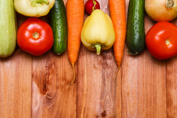 Autumn cooking background with seasonal organic vegetables on wooden table, top view, copy space. Ingredients for autum seasonal soups and dishes.