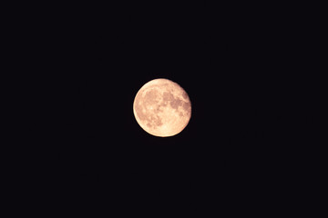 Bright light yellow full moon on dark black clear night sky zoom. Mystic nighttime black sky with...