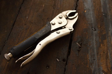 pressure pliers on a wooden table in a dirty workshop, work tool