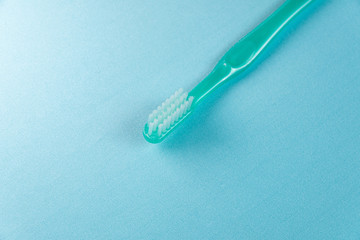 Green toothbrush on the blue background
