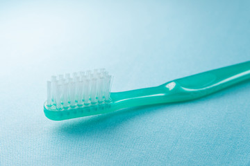 Green toothbrush on the blue background