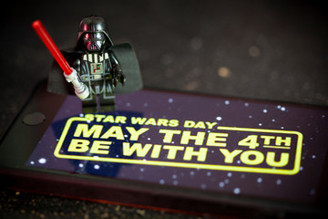 Naklejka premium NEW YORK USA, APRIL 28 2019: Darth Vader Lego Mini Figure with Star Wars wallpaper on an iPhone screen for Star Wars Day concept May the 4th Be With You