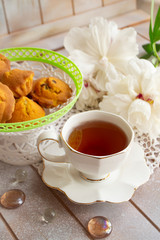 Afternoon tea served with a cupcakes, shabby table with white peony