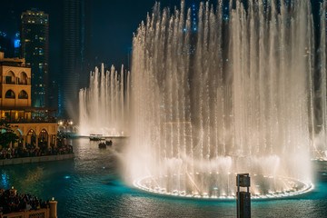 Dancing fountain show in Dubai center in evening, UAE. Tourist attraction.