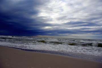 Sunset over the sea. Sunset on the beach. Dark storm clouds over the sea. Sunset at the beach. Storm on the sea.
